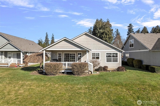 back of property featuring a porch and a lawn