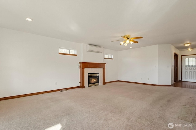 unfurnished living room with baseboards, a tiled fireplace, a wall mounted air conditioner, and light colored carpet