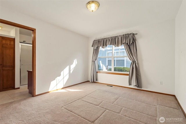 empty room featuring light carpet, baseboards, and visible vents