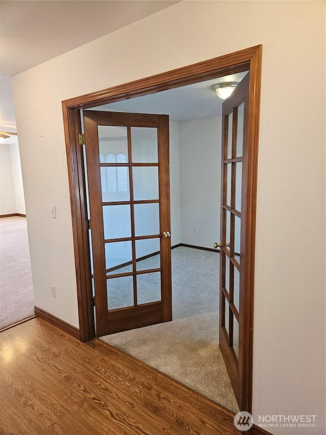 entryway with carpet floors, french doors, wood finished floors, and baseboards