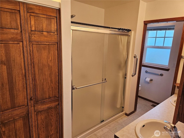 full bathroom featuring toilet, a stall shower, tile patterned flooring, and vanity