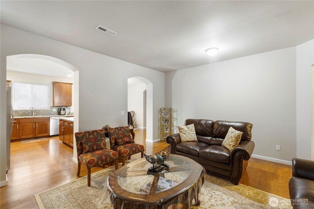 13019 SE 309th Pl, Auburn, WA 98092 - living area featuring arched walkways, visible vents, light wood finished floors, and baseboards