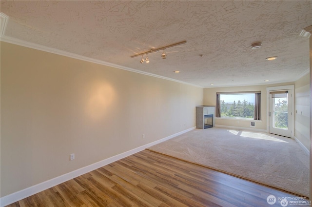 unfurnished living room featuring ornamental molding, a tile fireplace, baseboards, and wood finished floors