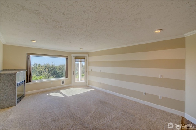 unfurnished living room with a textured ceiling, recessed lighting, baseboards, ornamental molding, and carpet