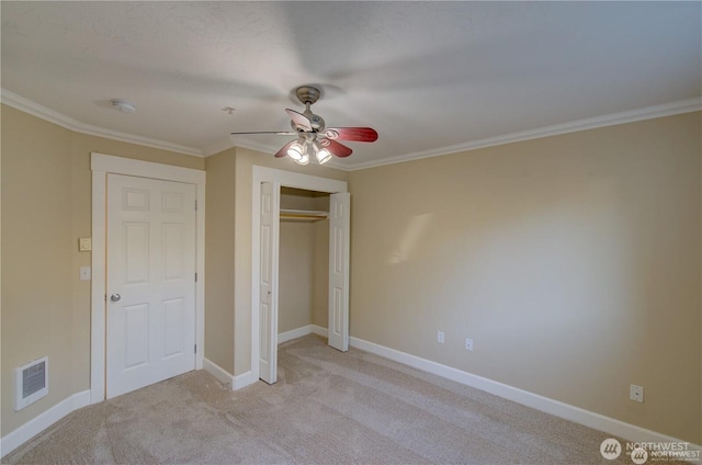 unfurnished bedroom featuring crown molding, baseboards, visible vents, and light colored carpet