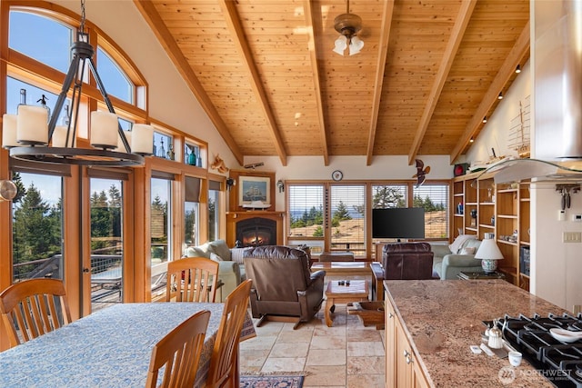 312 Stormridge Rd, Friday Harbor, WA 98250 - dining space with a warm lit fireplace, beamed ceiling, wood ceiling, and stone tile flooring