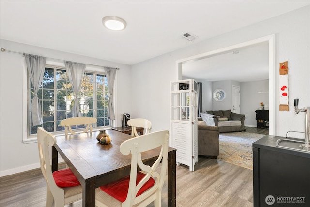 dining area featuring baseboards, visible vents, and light wood-style floors