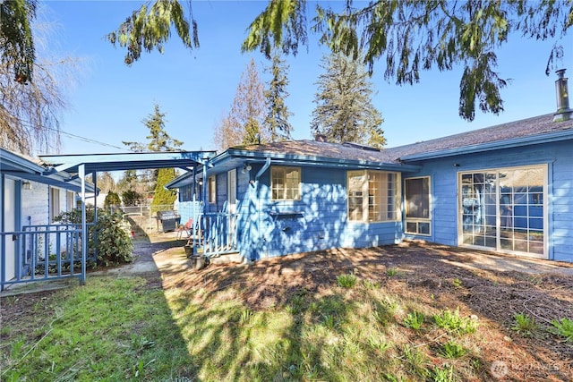 rear view of house featuring fence