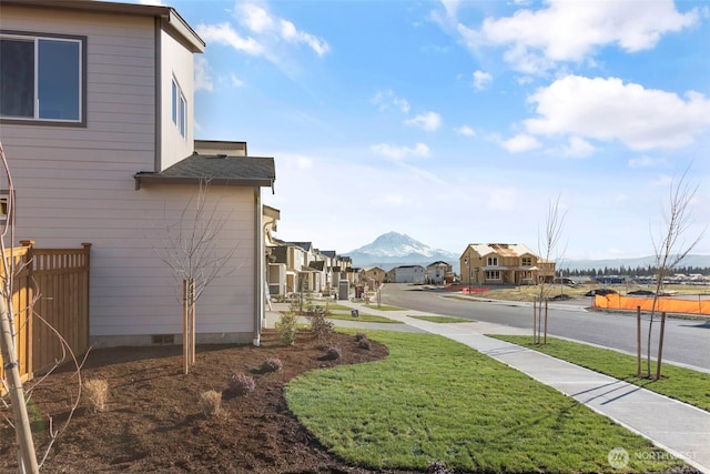 view of yard with a residential view, fence, and a mountain view