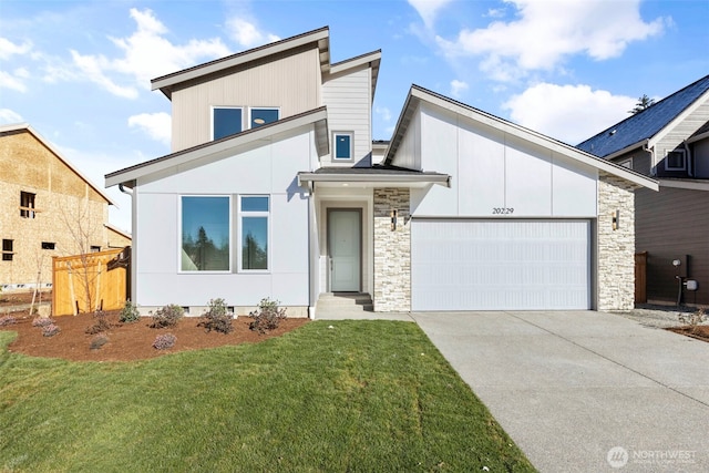 view of front facade featuring entry steps, concrete driveway, a front lawn, and an attached garage