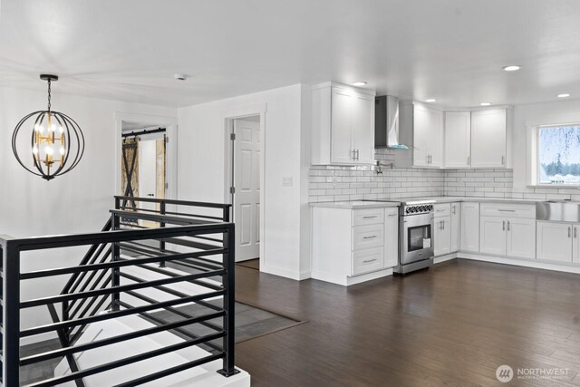 kitchen featuring high end stove, light countertops, wall chimney range hood, and backsplash