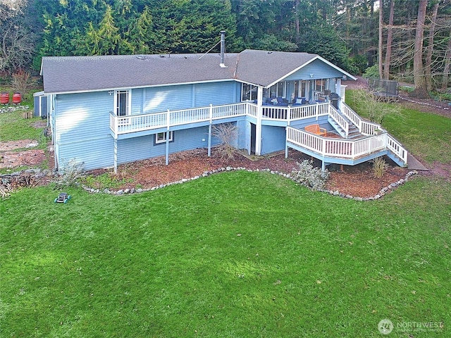 back of house with a deck, a shingled roof, stairs, a yard, and a forest view