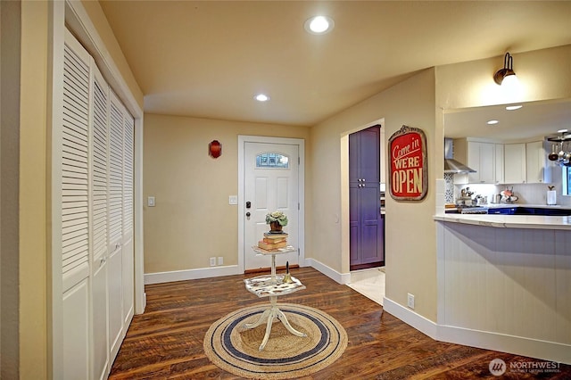 entrance foyer with baseboards, wood finished floors, and recessed lighting