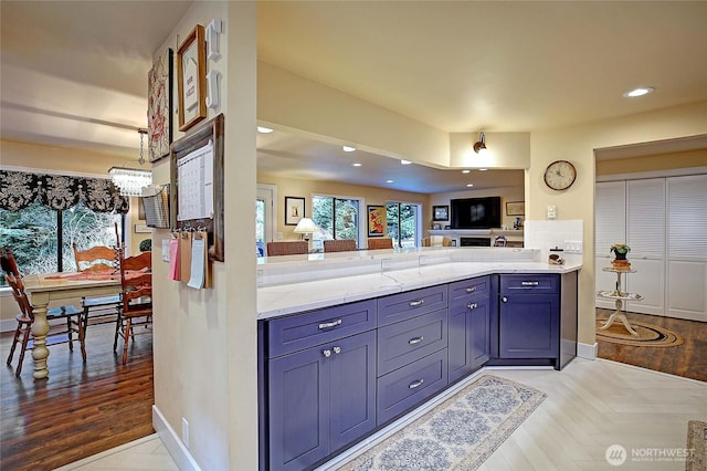 kitchen with baseboards, recessed lighting, an inviting chandelier, and light stone countertops