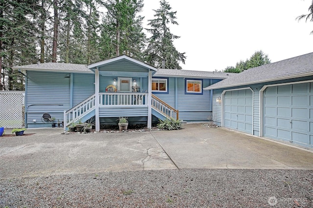 view of front facade with a garage, covered porch, and driveway