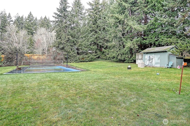 view of yard featuring ac unit, an outbuilding, a tennis court, and fence