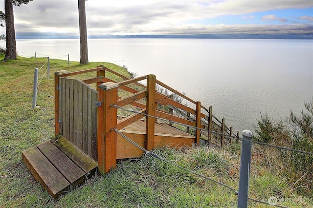 exterior space featuring a water view and fence