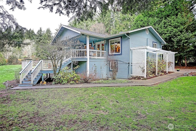 rear view of house with a lawn and stairway