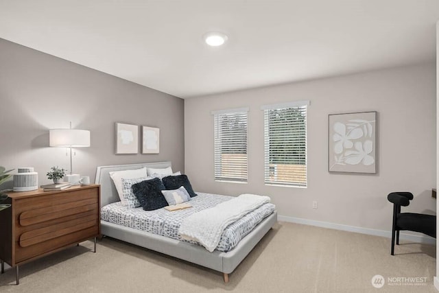 bedroom with light colored carpet and baseboards