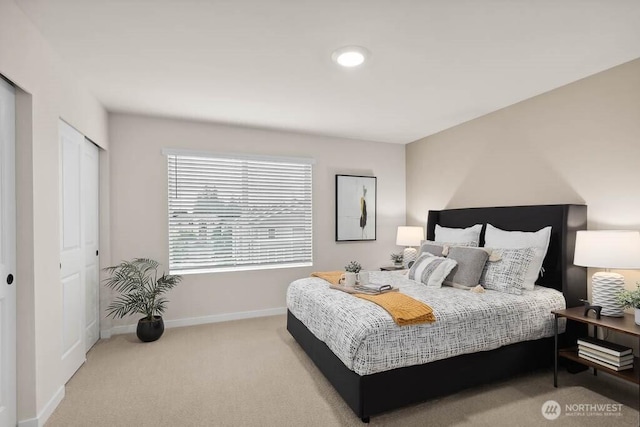 bedroom featuring light colored carpet and baseboards