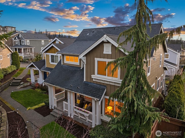 view of front of home featuring a shingled roof, a residential view, and board and batten siding