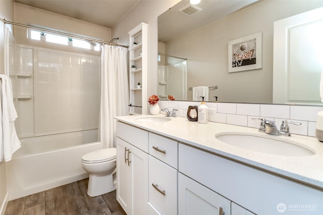 full bathroom featuring wood finished floors, a sink, visible vents, and shower / bathtub combination with curtain