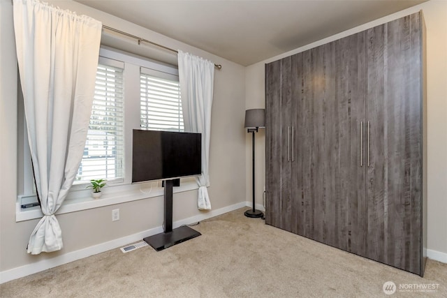 unfurnished living room with baseboards, visible vents, and carpet flooring