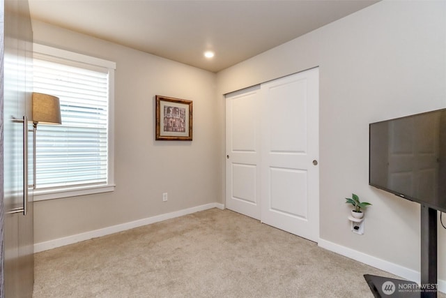 unfurnished bedroom featuring a closet, recessed lighting, carpet flooring, and baseboards