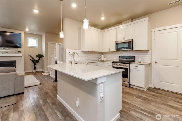 kitchen featuring stainless steel appliances, visible vents, a sink, and tasteful backsplash