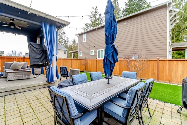 view of patio with ceiling fan, outdoor dining area, a fenced backyard, and an outdoor living space