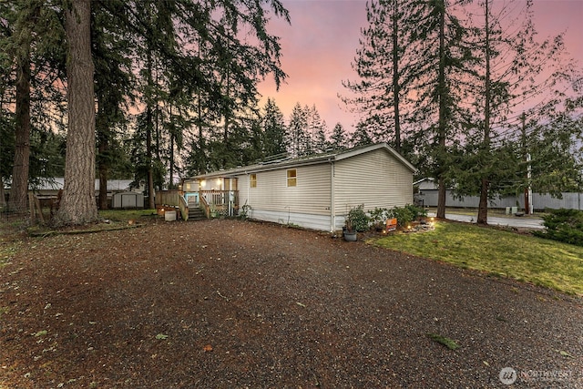 rear view of house featuring a storage shed and an outbuilding