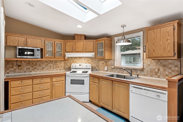 kitchen featuring under cabinet range hood, white appliances, a sink, light countertops, and backsplash