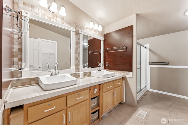 full bathroom featuring a stall shower, tile patterned flooring, and a sink