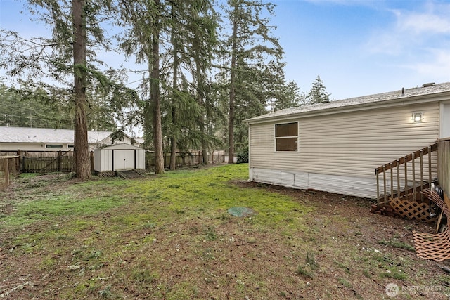 view of yard featuring an outbuilding, a storage unit, and a fenced backyard