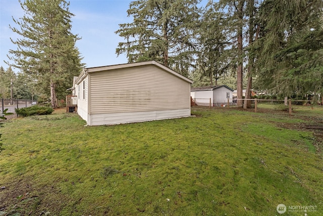 view of property exterior featuring fence and a lawn