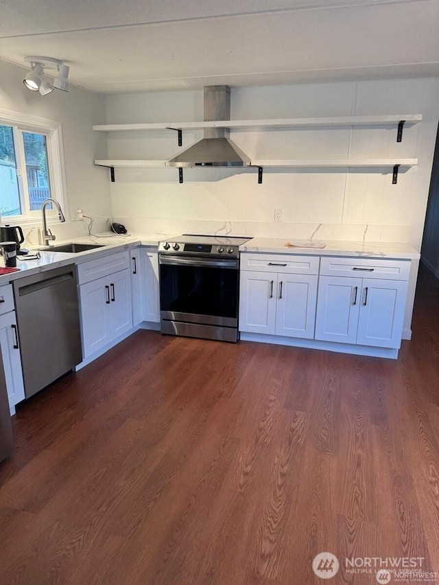 kitchen featuring wall chimney exhaust hood, appliances with stainless steel finishes, dark wood-style flooring, open shelves, and a sink