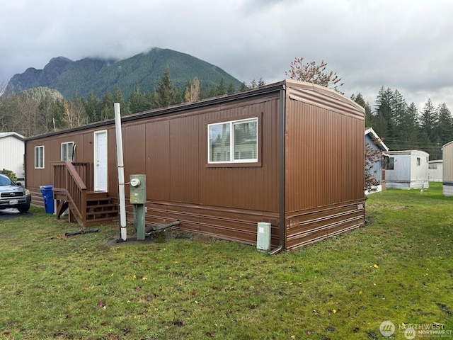 view of property exterior with a lawn and a mountain view