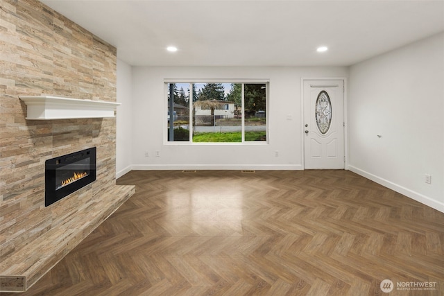 unfurnished living room featuring recessed lighting, a tile fireplace, and baseboards