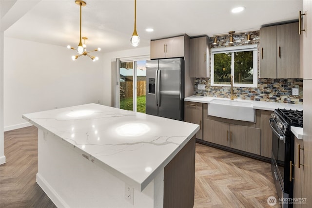 kitchen with backsplash, gas stove, a kitchen island, a sink, and stainless steel fridge with ice dispenser