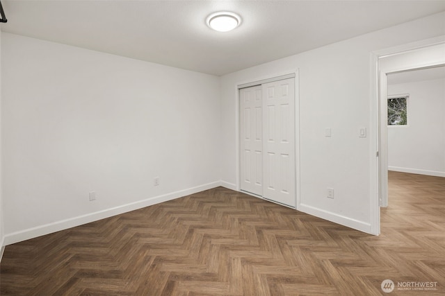 unfurnished bedroom featuring a closet and baseboards