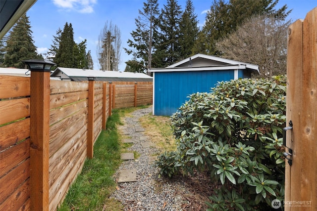 view of yard featuring an outbuilding, a shed, and a fenced backyard