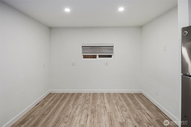 spare room featuring baseboards, wood finished floors, and recessed lighting