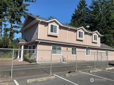 view of home's exterior featuring uncovered parking and fence