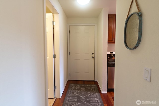 corridor featuring baseboards and dark wood-type flooring