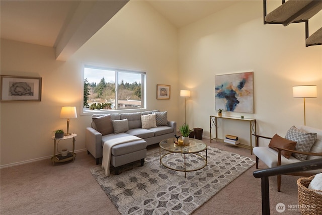 carpeted living area featuring baseboards and high vaulted ceiling