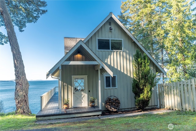 view of front of house featuring board and batten siding, a water view, and fence