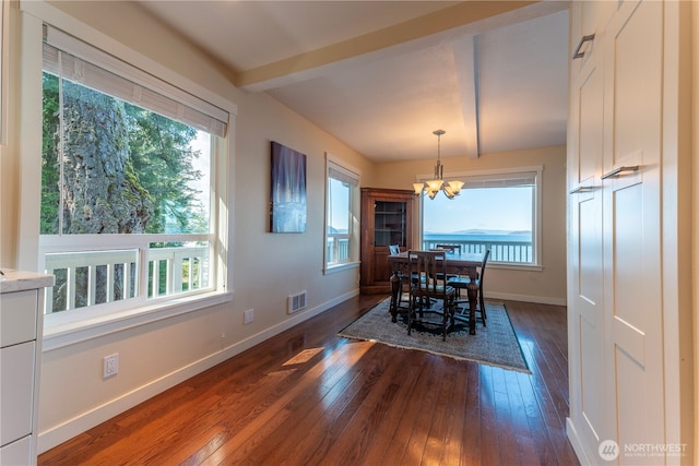 dining room featuring a chandelier, visible vents, beamed ceiling, and dark wood-type flooring