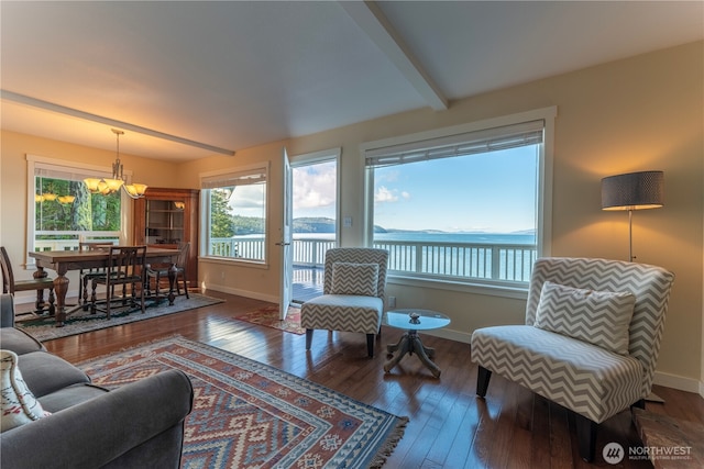 living area featuring baseboards, beam ceiling, a notable chandelier, and hardwood / wood-style flooring