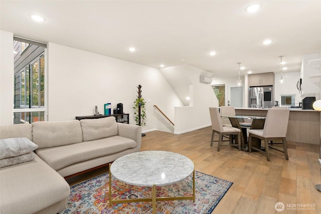 living area featuring recessed lighting, baseboards, and light wood finished floors