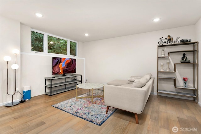 living area with baseboards, wood finished floors, and recessed lighting